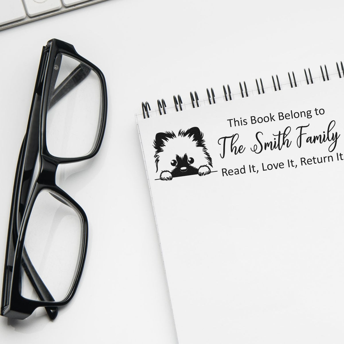 Trodat Keeshond self-inking dog-themed library stamp in use, featuring personalized dog illustration and clear, detailed imprint.