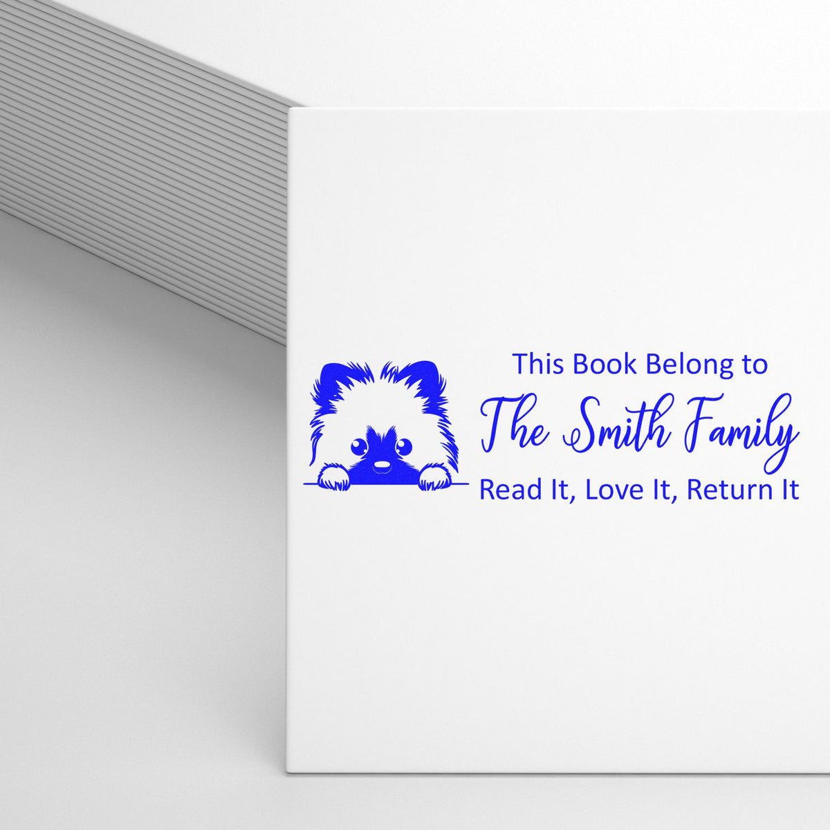 Self-inking Keeshond dog-themed library stamp by Trodat in use, showing detailed Keeshond design for personalized dog stamps.