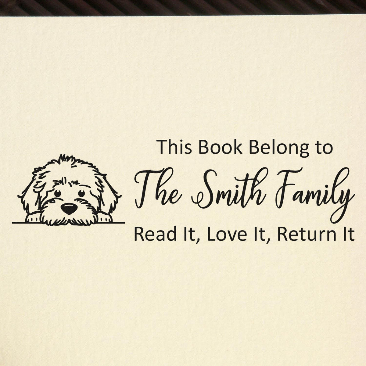 Black custom book stamp with dog seal and text This Book Belong to The Smith Family on a cream background.
