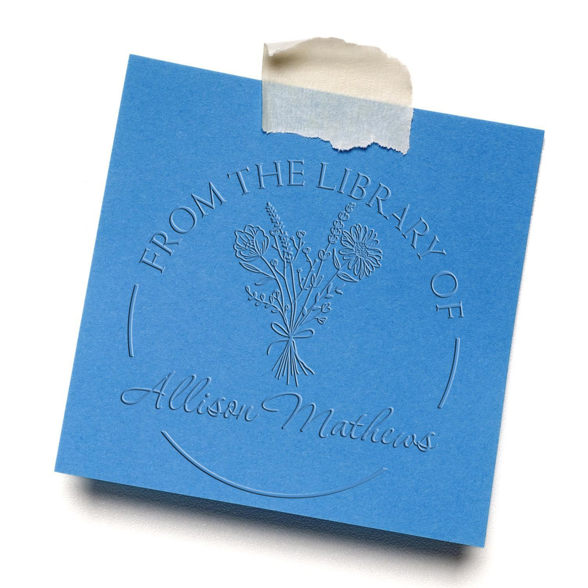 Shiny floral stamps with scripted "Read It Love It Return It" design used for embossing on paper, featuring a vibrant floral pattern.