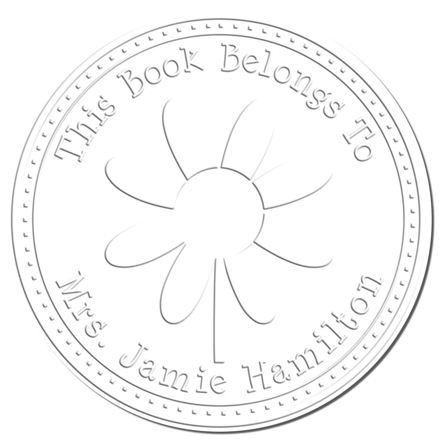 Round white embossed book stamp seal with floral emblem and text This Book Belongs To Jamie Hamilton