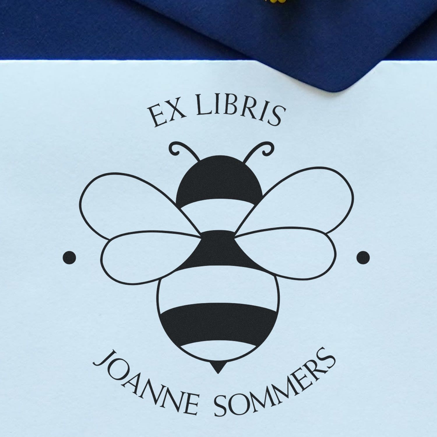 Black bee ex libris bookplate stamp and seal on pale blue paper with dark blue envelope, for Joanne Sommers.