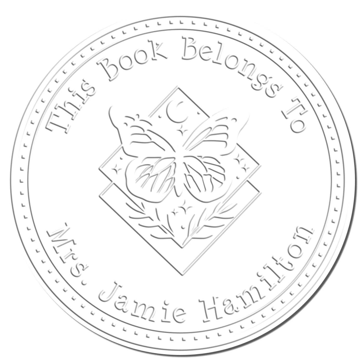 Light gray circular book stamp seal with butterfly and floral design, reading "This Book Belongs To Mrs Jamie Hamilton"