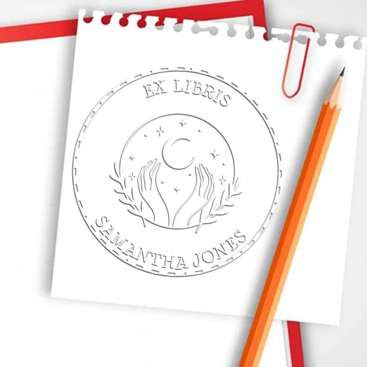Shiny celestial sphere personalized embossing stamp in use, featuring astrological symbols and elegant design for book personalization.