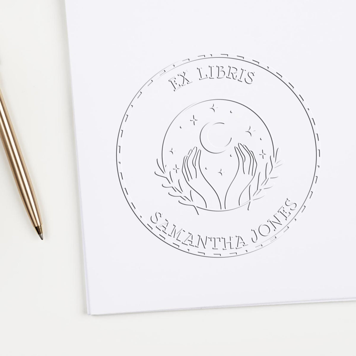 Shiny celestial sphere personalized embossing stamp with astrological design in use on paper, ideal for book embossing projects.