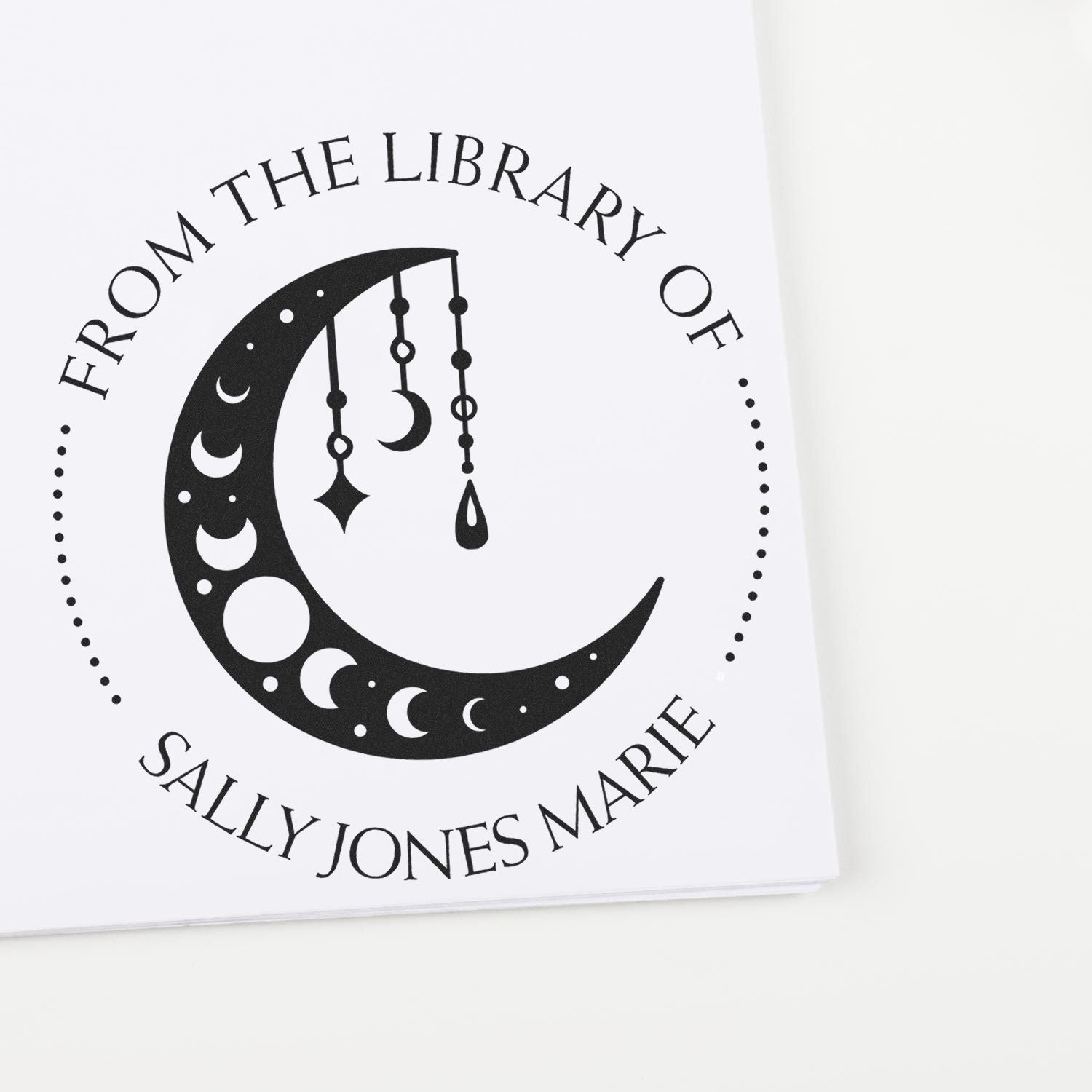 Black custom stamp seal with crescent moon and hanging charms, reading From the Library of Sally Jones Marie