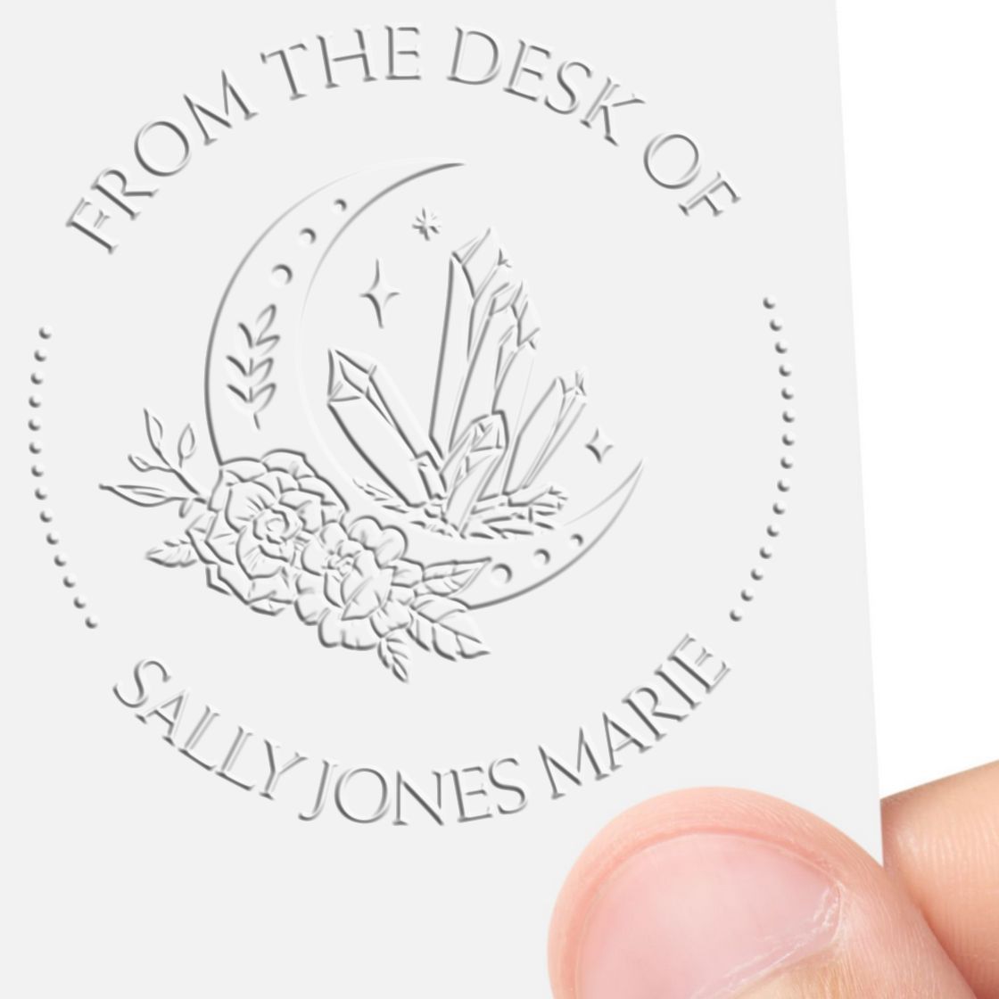 Custom embossed stamp seal with moon, crystals, and flowers; From the Desk of Sally Jones Marie on white card.