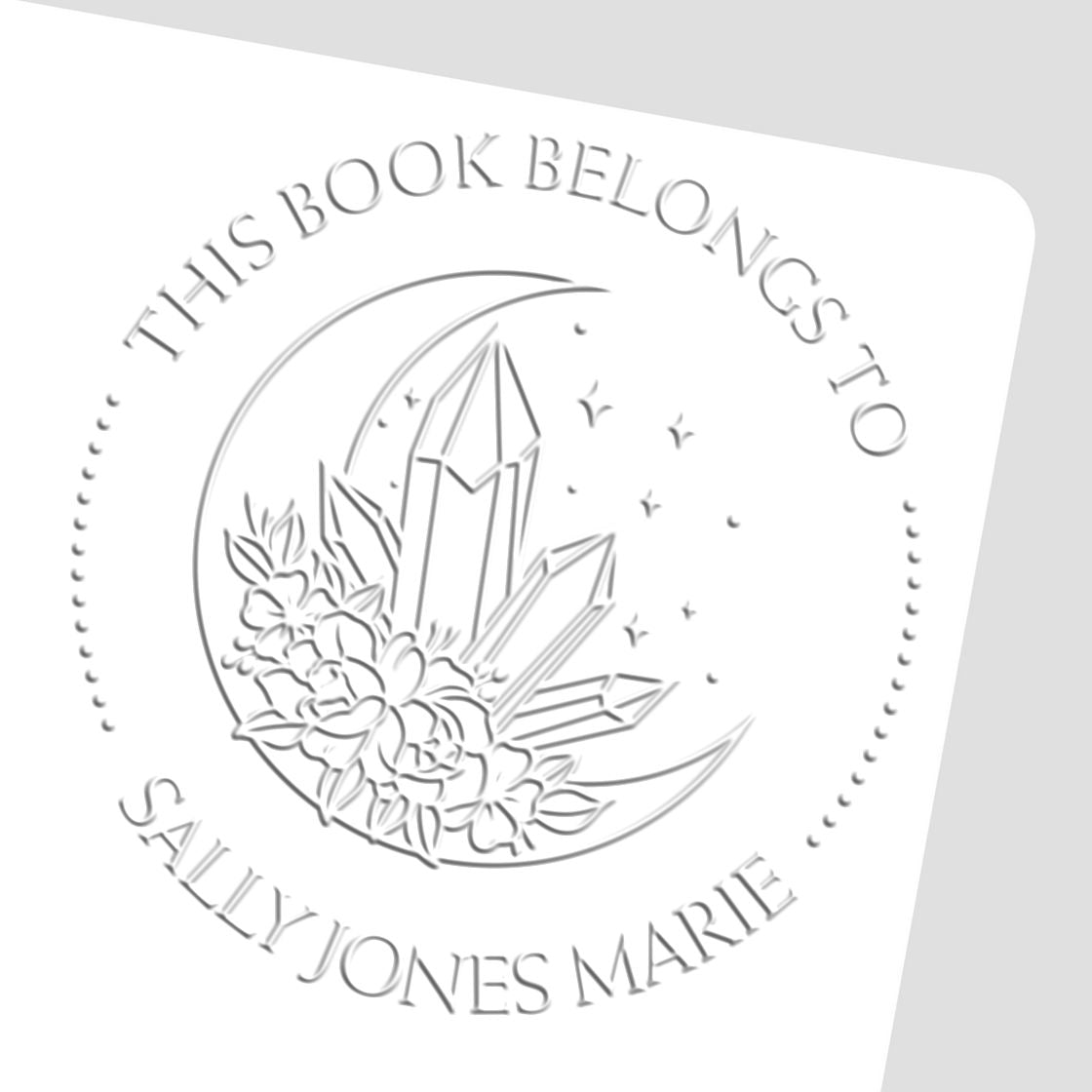 White embossed stamp seal with crystal and floral design, reading This Book Belongs to Sally Jones Marie