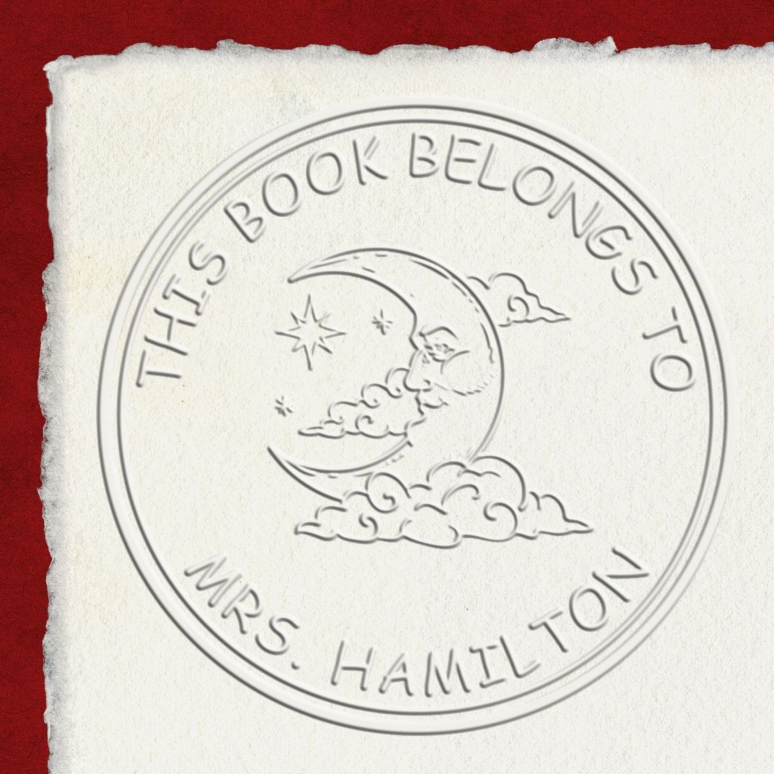 Embossed circular bookplate seal on white paper with moon and clouds, red background, for Mrs. Hamilton.