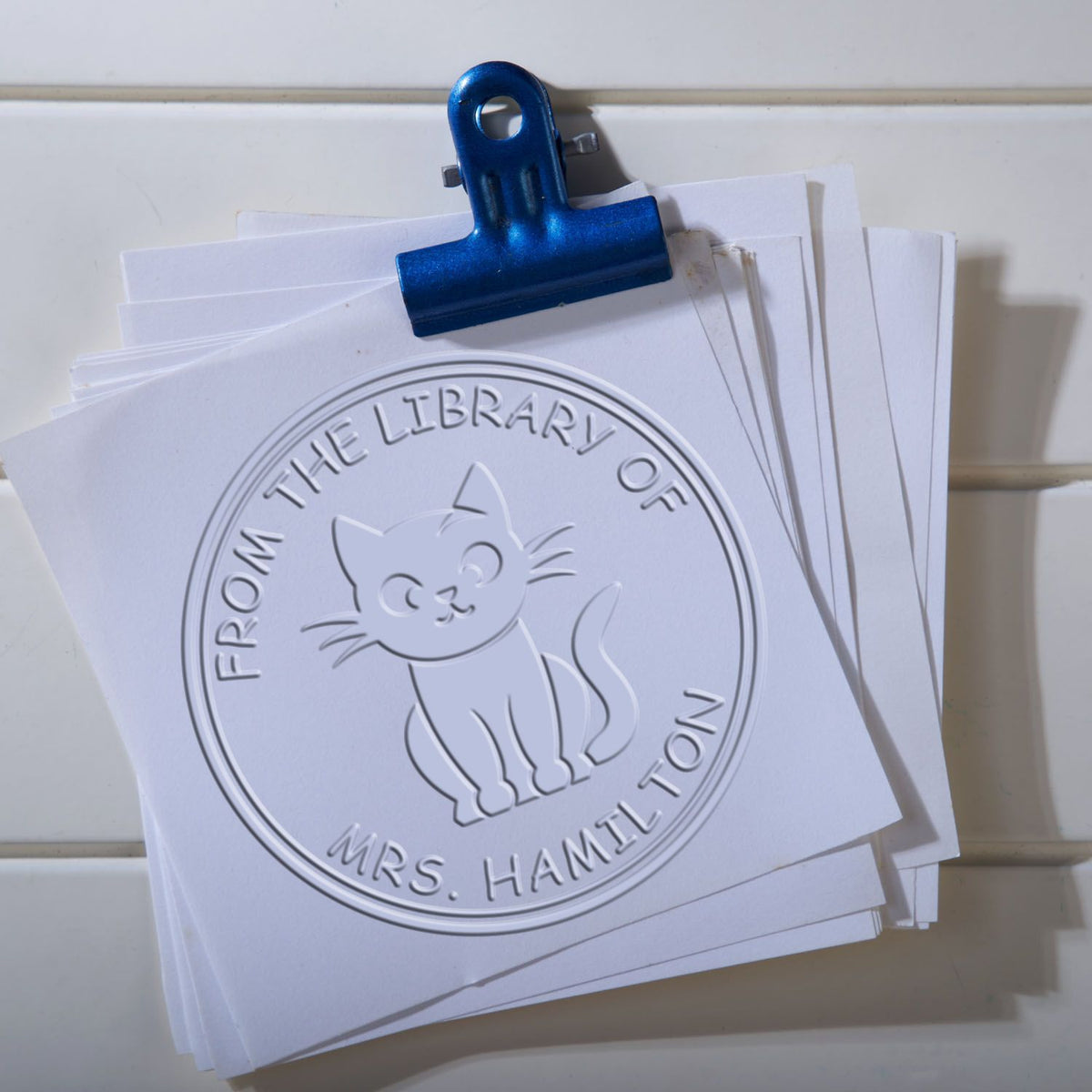 Shiny Soft Curious Kitty Custom Belongs To embossing stamp featuring a cute cat design in use on paper.
