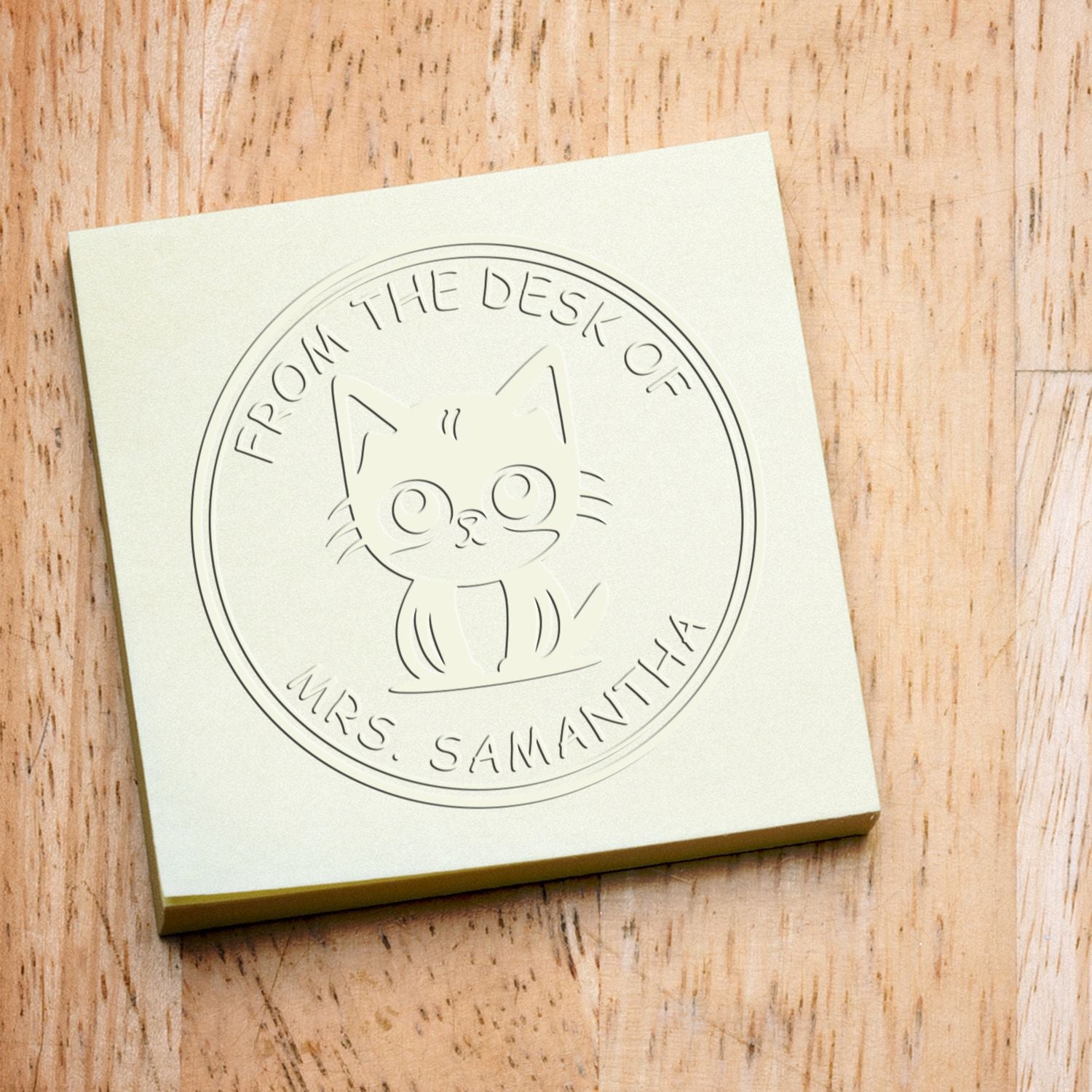 Cream custom stamp and seal with cat emblem and From the Desk of Mrs. Samantha on a wood background.
