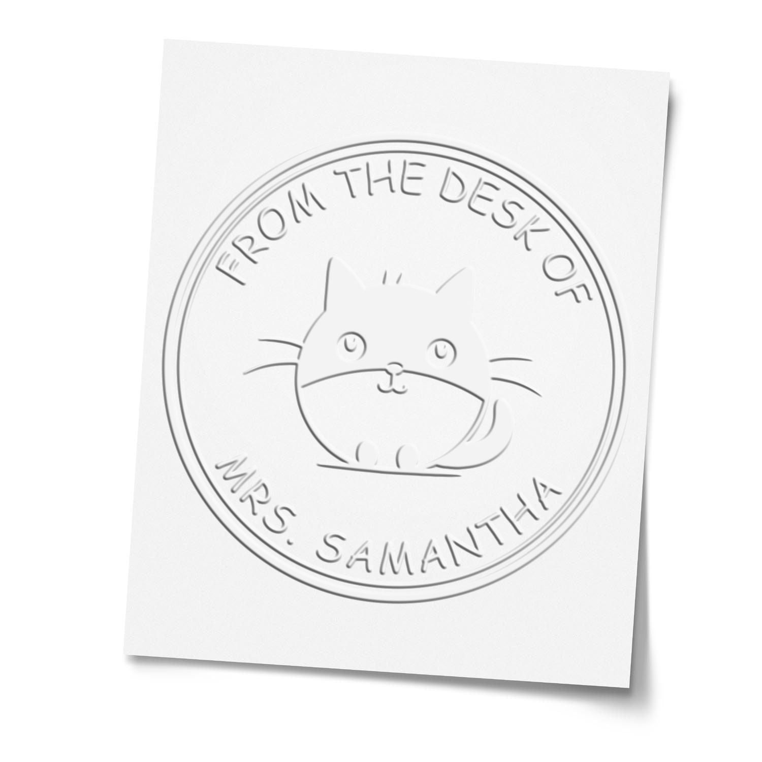 White embossed circular desk seal with cat design and From the Desk of Mrs. Samantha text on white paper.