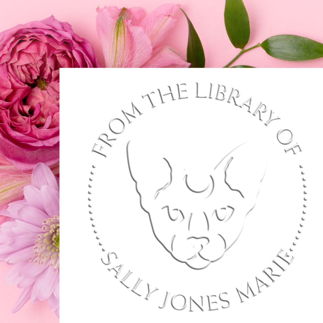 White embossed custom stamp seal with circular text and dog face logo on a pink floral background.