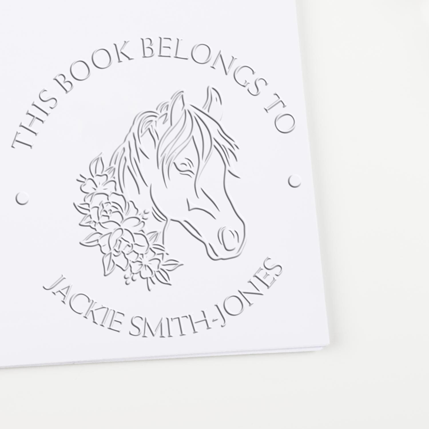 White embossed horse and floral book stamp seal with gray text: This Book Belongs to Jackie Smith-Jones