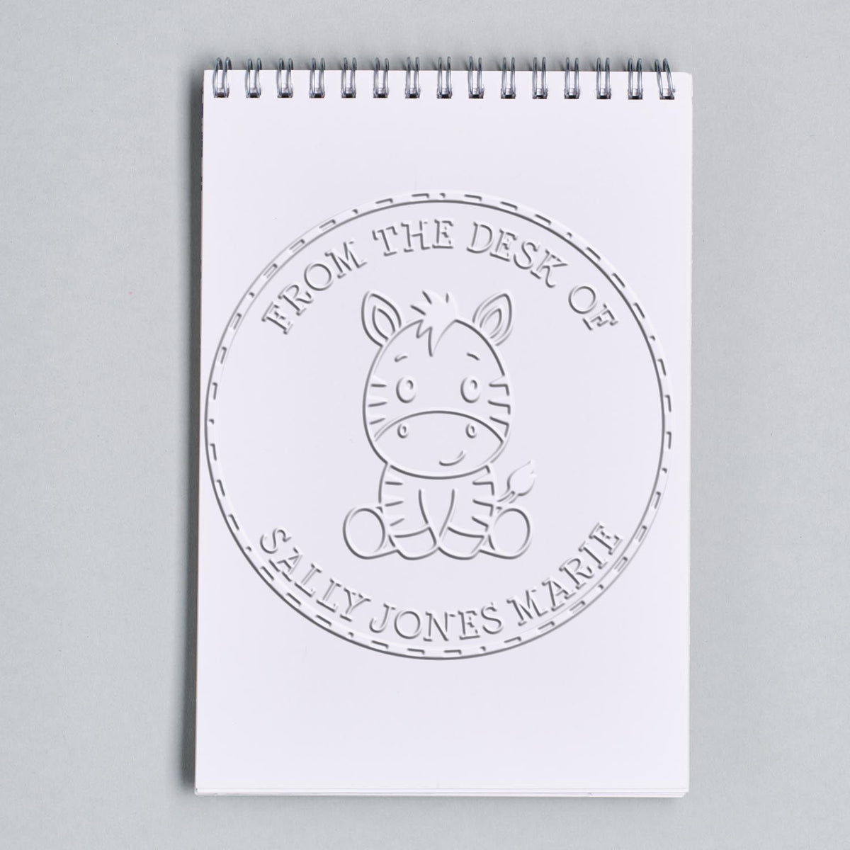 Shiny soft baby zebra embossing stamp with "This Book Belongs To" design, used for customizing books and stationery.