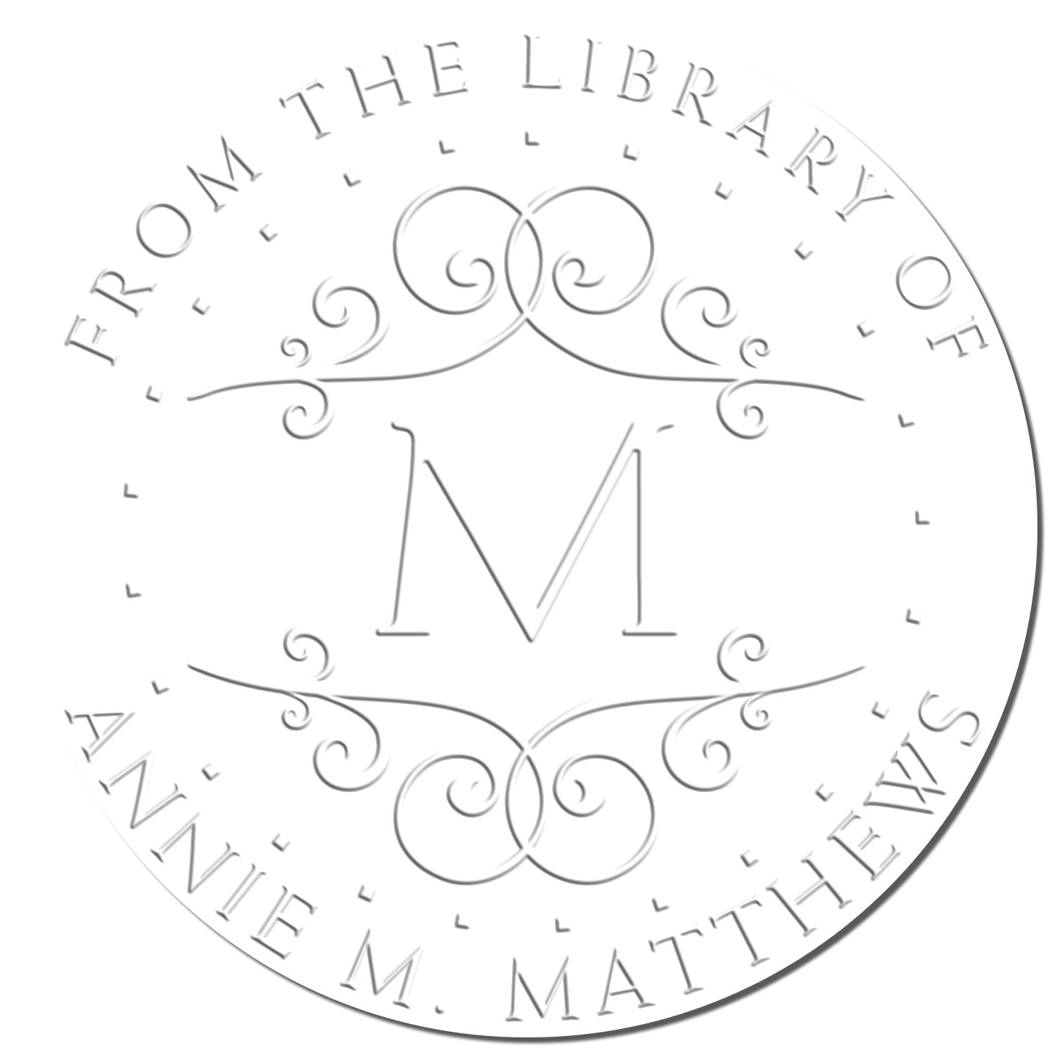 White and silver-gray library stamp seal with ornate monogram M and circular text reading From the Library of Anne M. Matthews