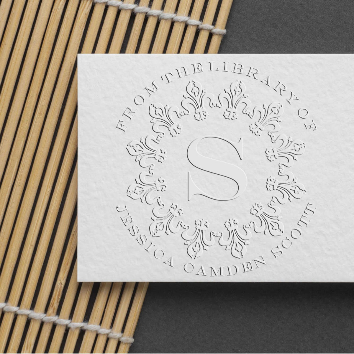 Shiny soft bold initials custom library paper embosser in use, creating raised initials on paper for personalized stationery.