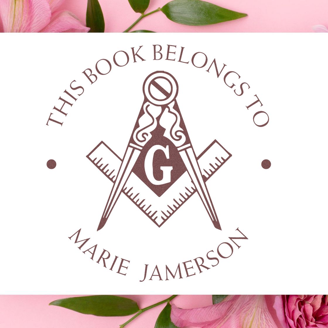 Brown custom stamp and seal with compass and G, reading This Book Belongs to Marie Jamerson, on white with pink florals.