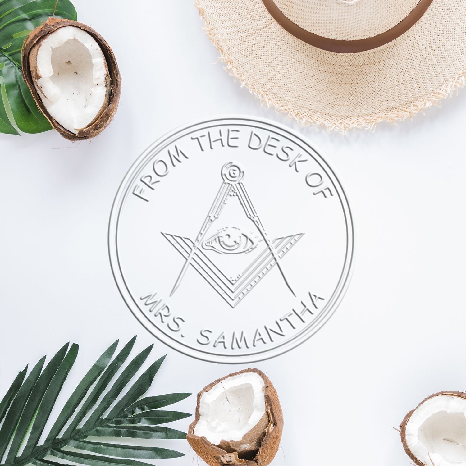 Silver custom stamp and seal logo on white with tropical coconut shells, green leaves, and a straw hat.