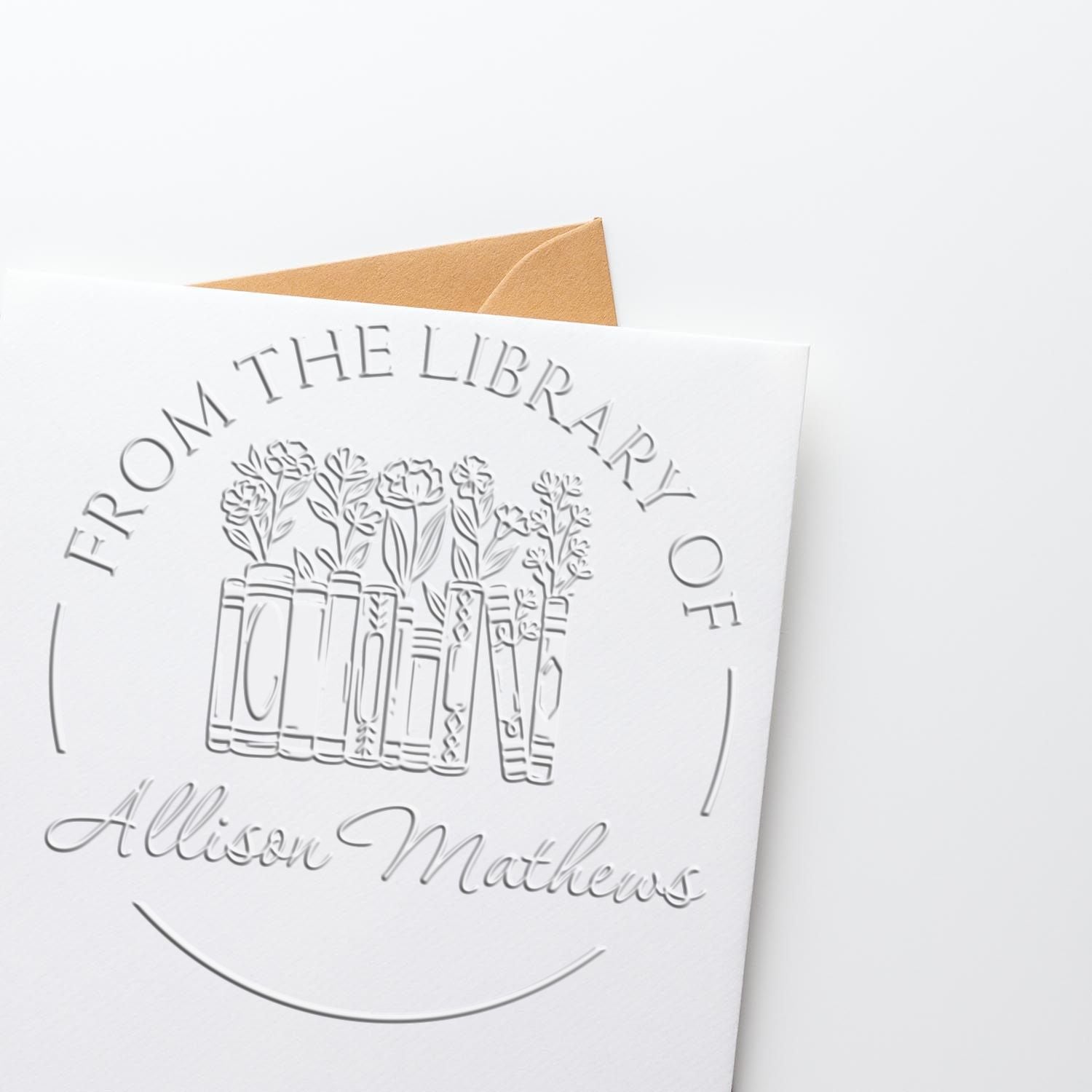 Embossed white stamp and seal card with book-and-flower logo for Allison Mathews, backed by a tan envelope.