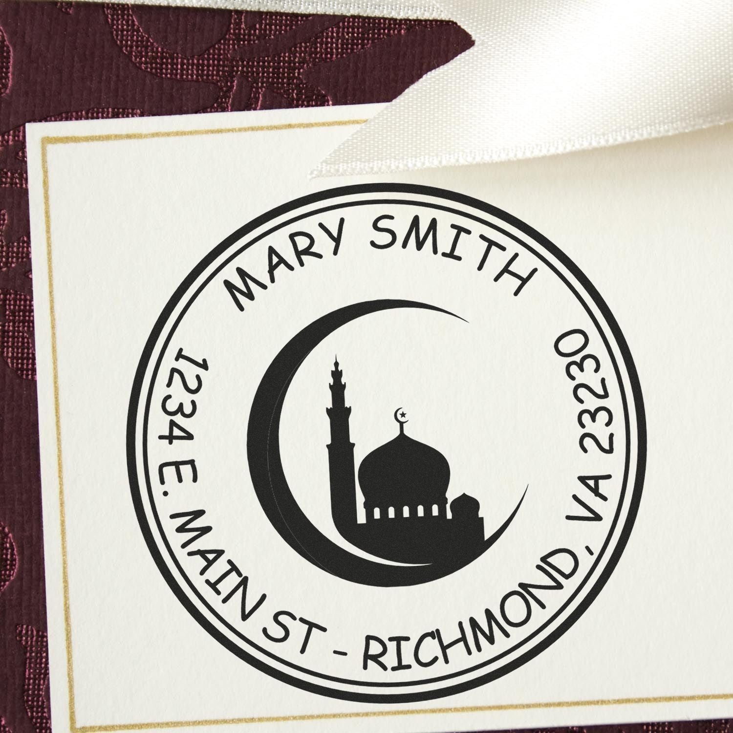 Black custom stamp and seal with crescent mosque design on white card, gold border, and purple textured background.