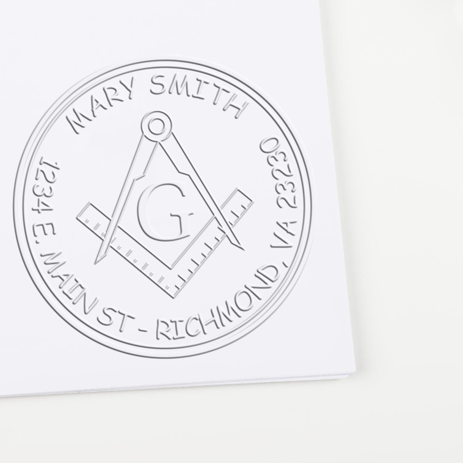 Embossed gray circular seal stamp with compass, square and G emblem on white paper.