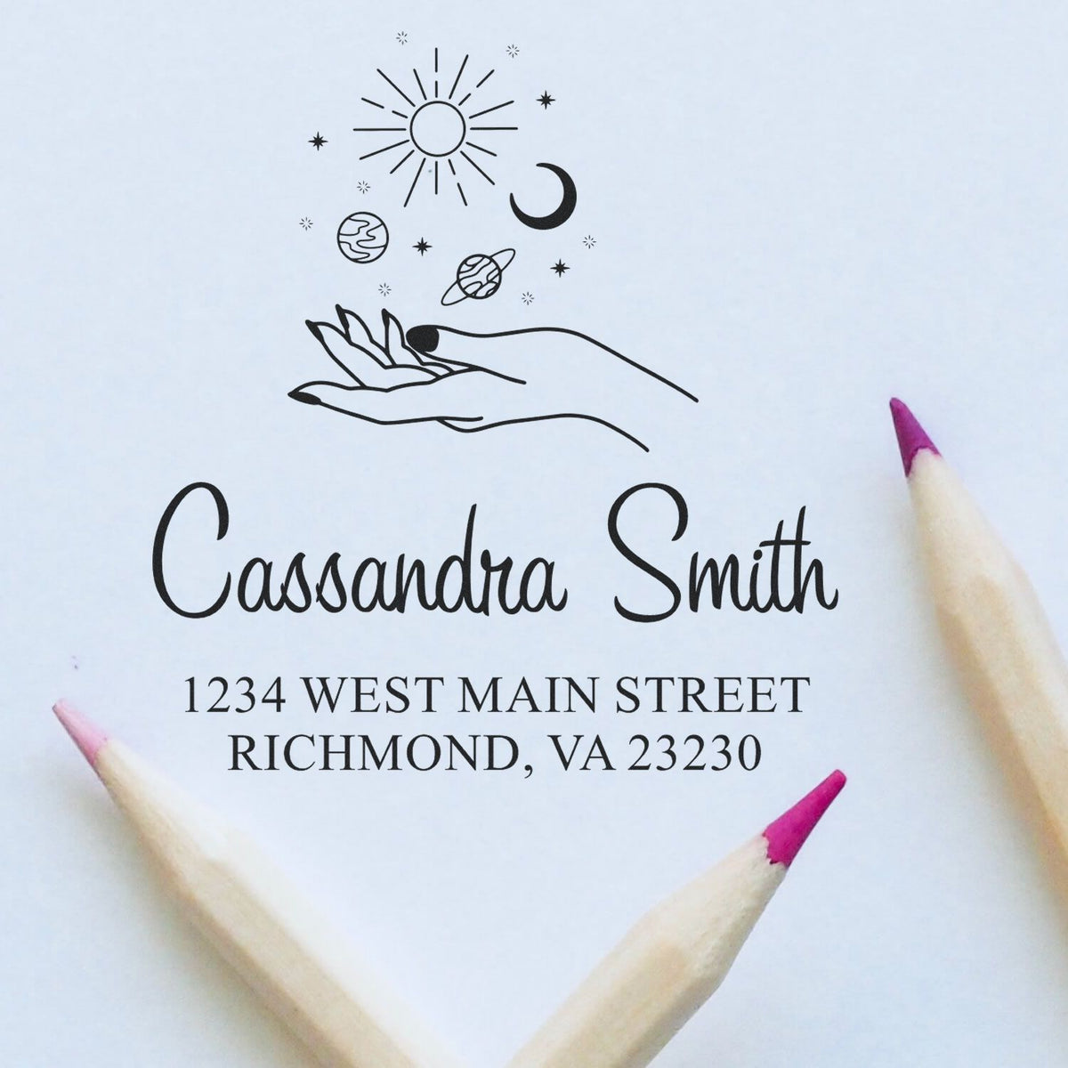 Black custom stamp and seal design with hand, sun, moon and stars above Cassandra Smith address on white paper.