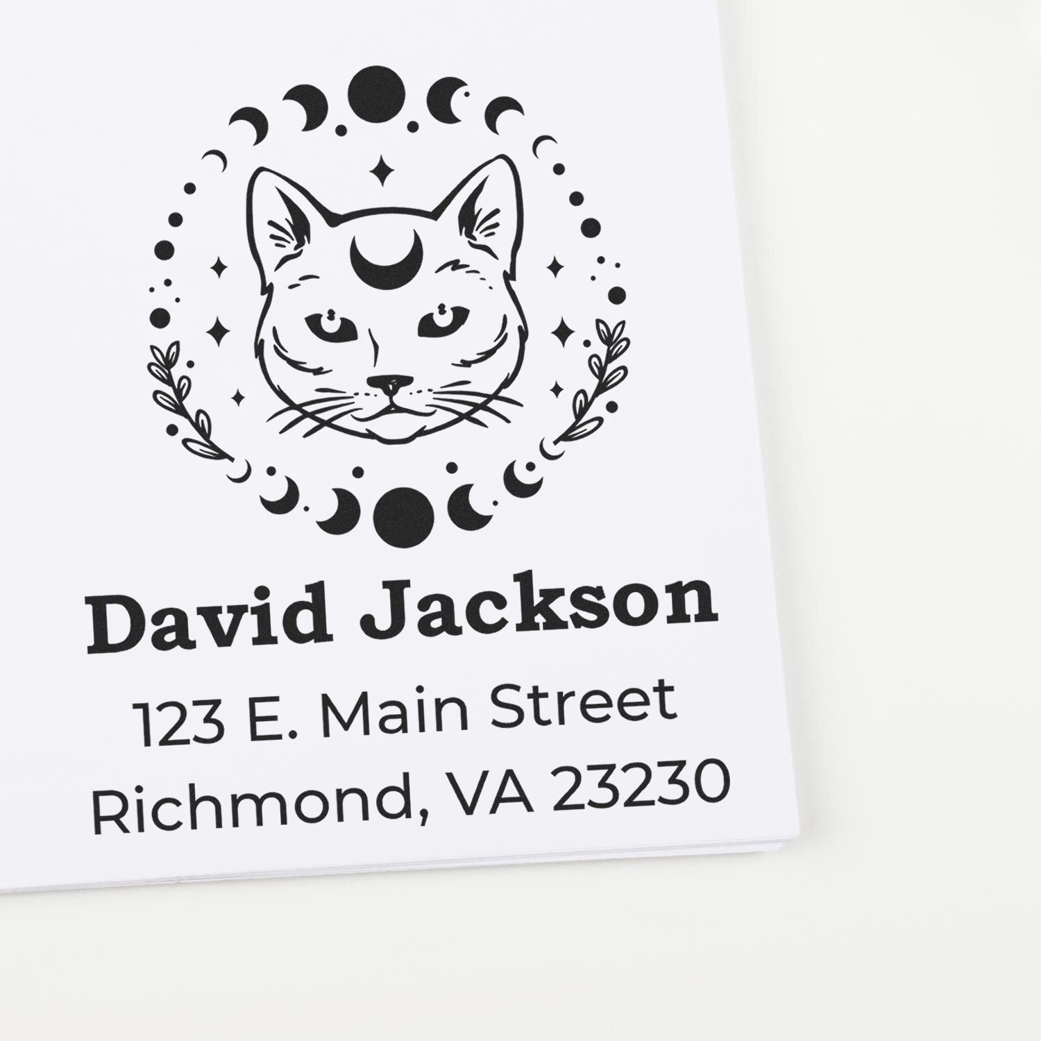 Custom black-on-white cat celestial address stamp and seal with moon phases, David Jackson, 123 E. Main Street, Richmond, VA 23230.