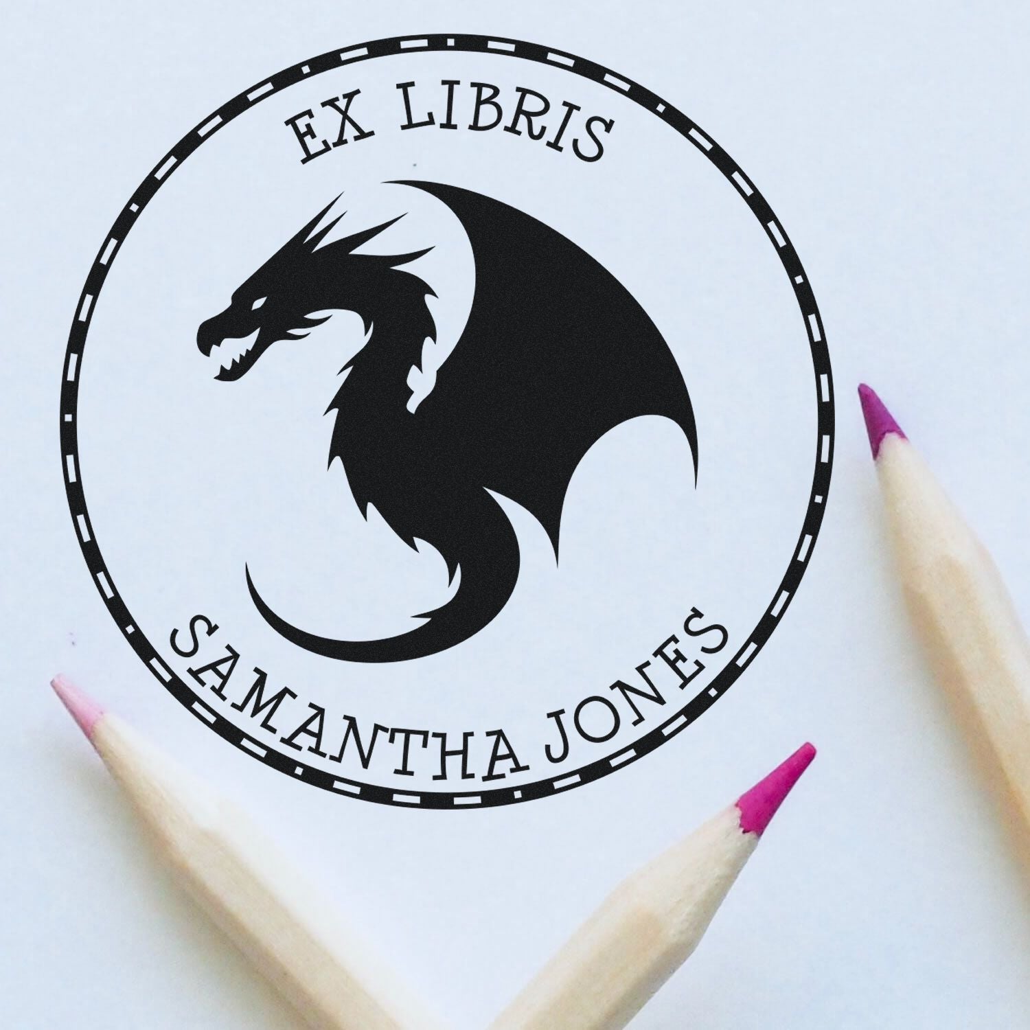 Custom black dragon ex libris stamp seal with EX LIBRIS and SAMANTHA JONES, framed by pink-tipped pencils.