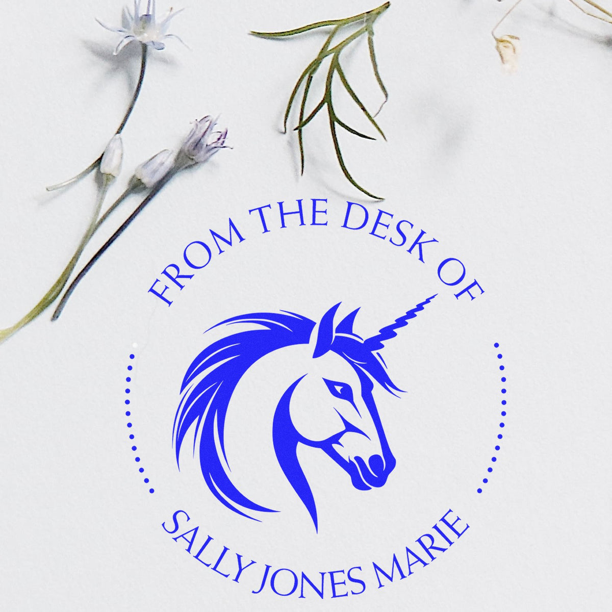 Blue unicorn desk stamp seal with From the Desk of Sally Jones Marie on white, accented by delicate floral stems.