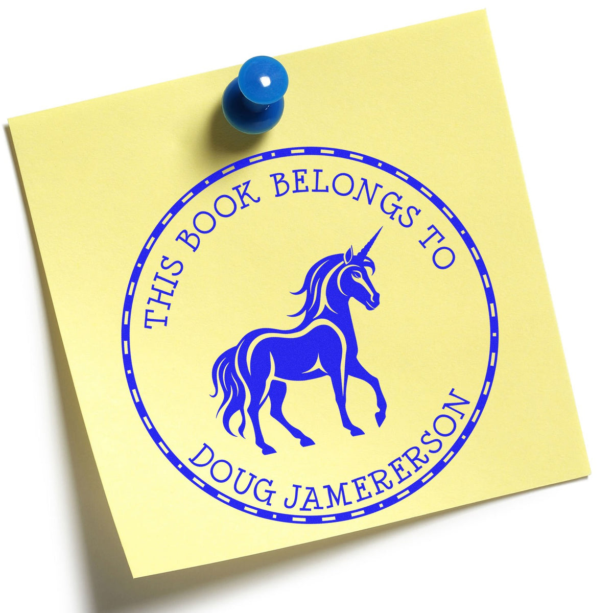 Yellow sticky note with blue unicorn bookplate stamp seal reading This Book Belongs to Doug Jamerson and a blue push pin.