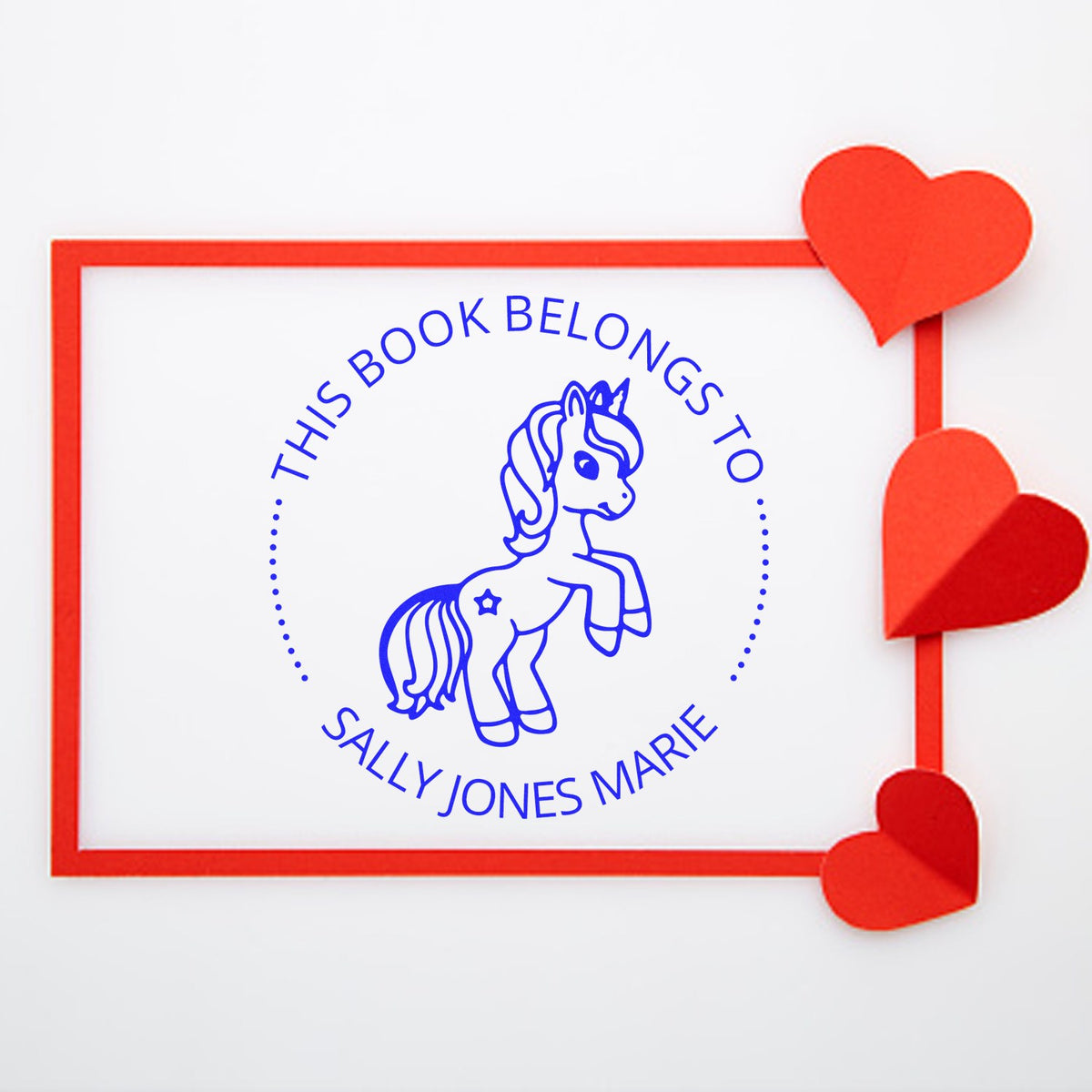 Blue unicorn book ownership stamp seal with Sally Jones Marie text, red border, and heart accents on white background.