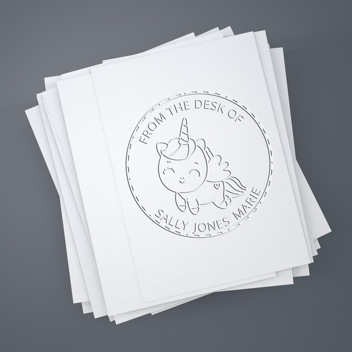 Stack of white paper cards with an embossed circular unicorn stamp seal reading From the Desk of Sally Jones Marie