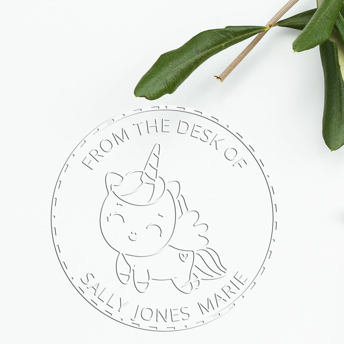 Round custom self-inking stamp seal with unicorn design, From the Desk of Sally Jones Marie, on white with green leaves.