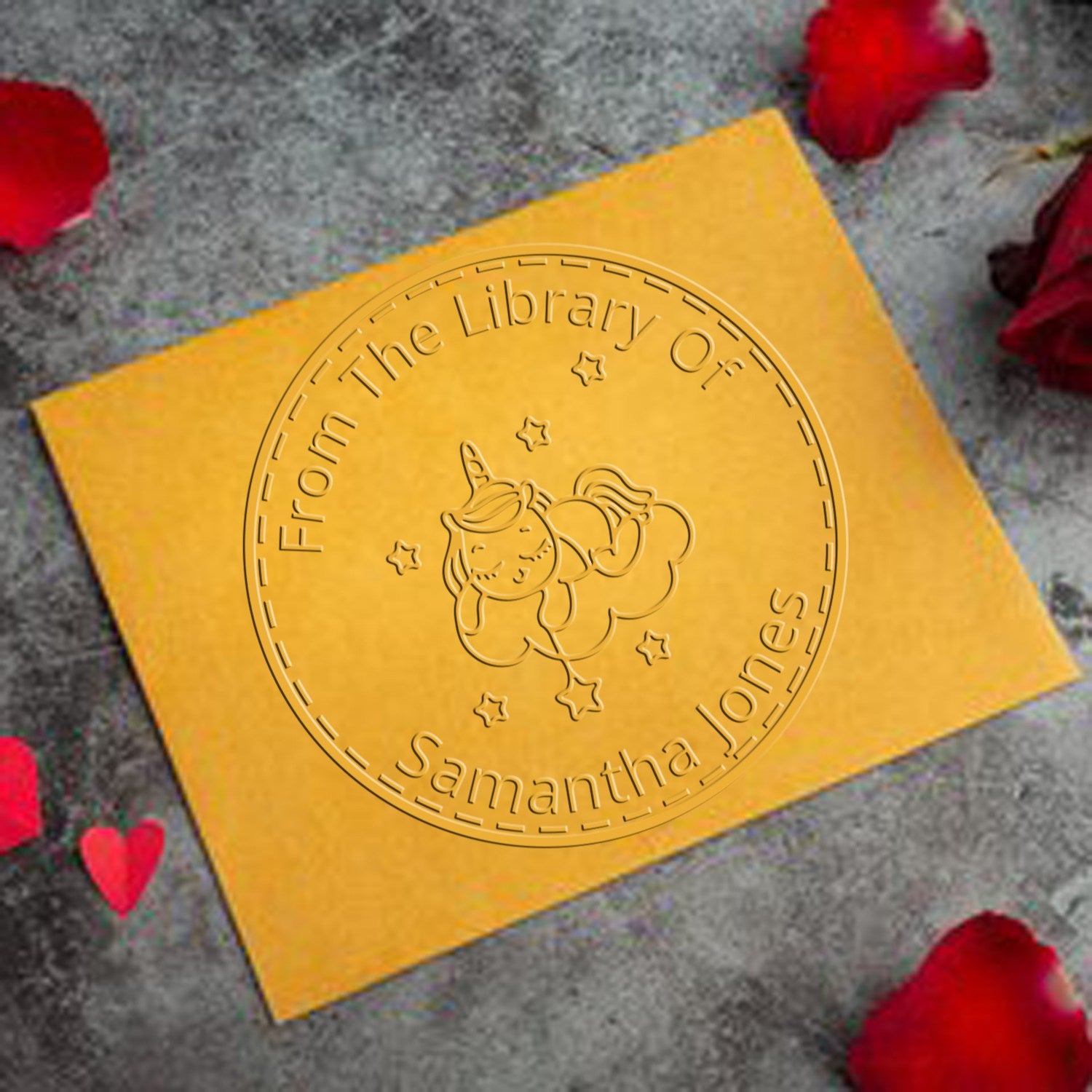 Gold embossed stamp seal with unicorn and stars on yellow card, reading From The Library Of Samantha Jones.
