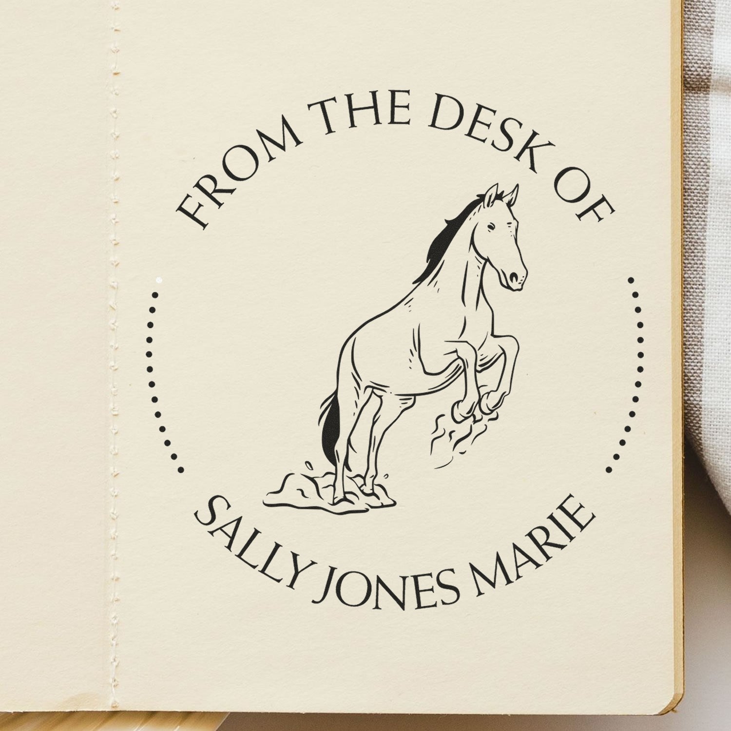 Cream stamp seal with black rearing horse and circular text From the Desk of Sally Jones Marie