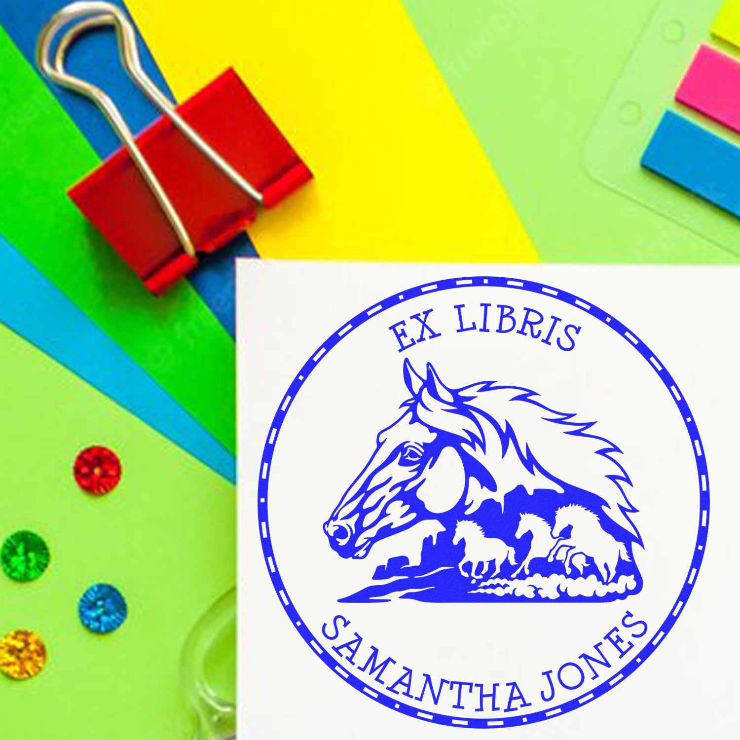 Blue ex libris horse stamp seal on white paper, with colorful neon green, yellow, pink, and blue stationery accents and red binder clip