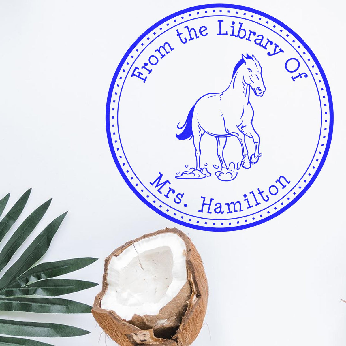 Blue circular library stamp seal with horse illustration and From the Library Of Mrs. Hamilton text on white background.