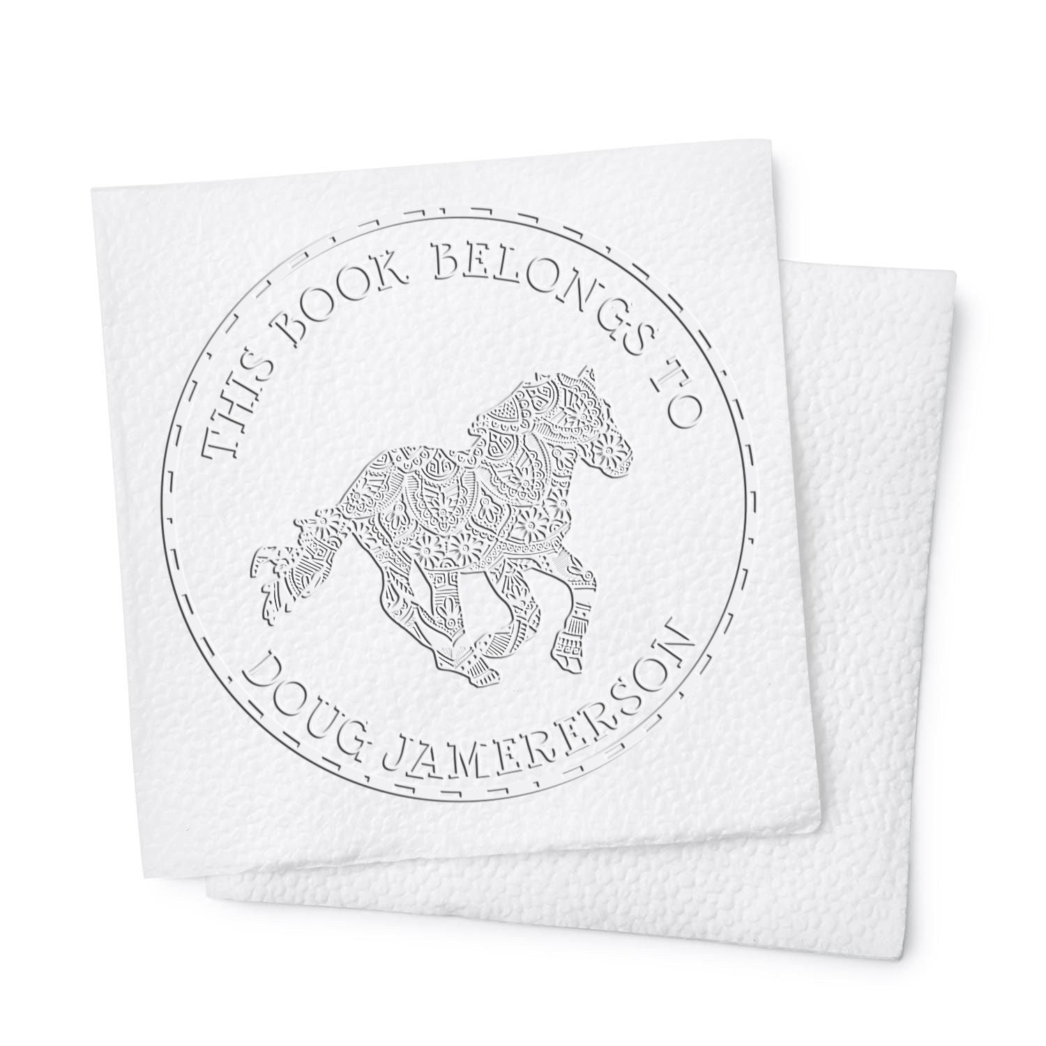 White embossed custom book stamp and seal with circular text and patterned horse on layered white cards.