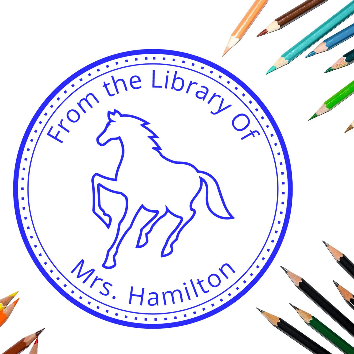 Blue circular library stamp seal with horse outline, From the Library Of Mrs. Hamilton, surrounded by colored pencils.