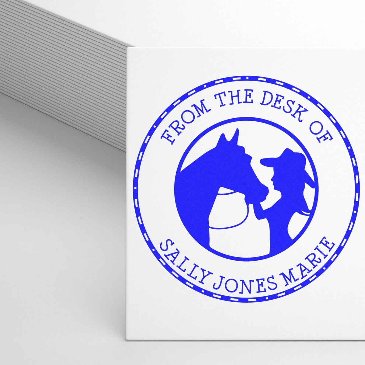 White custom stamp seal with blue circular horse-and-rider logo and From the Desk of Sally Jones Marie text.
