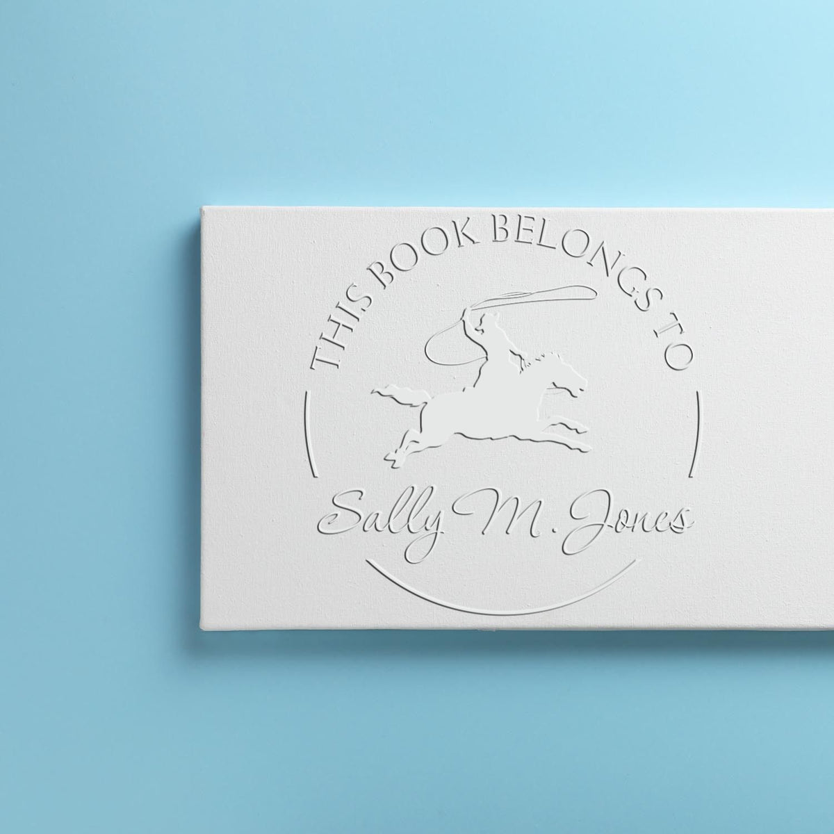 Trodat Swift Serenade Equestrian hybrid book embosser with farm animal stamps in use, personalized with custom ex libris design.
