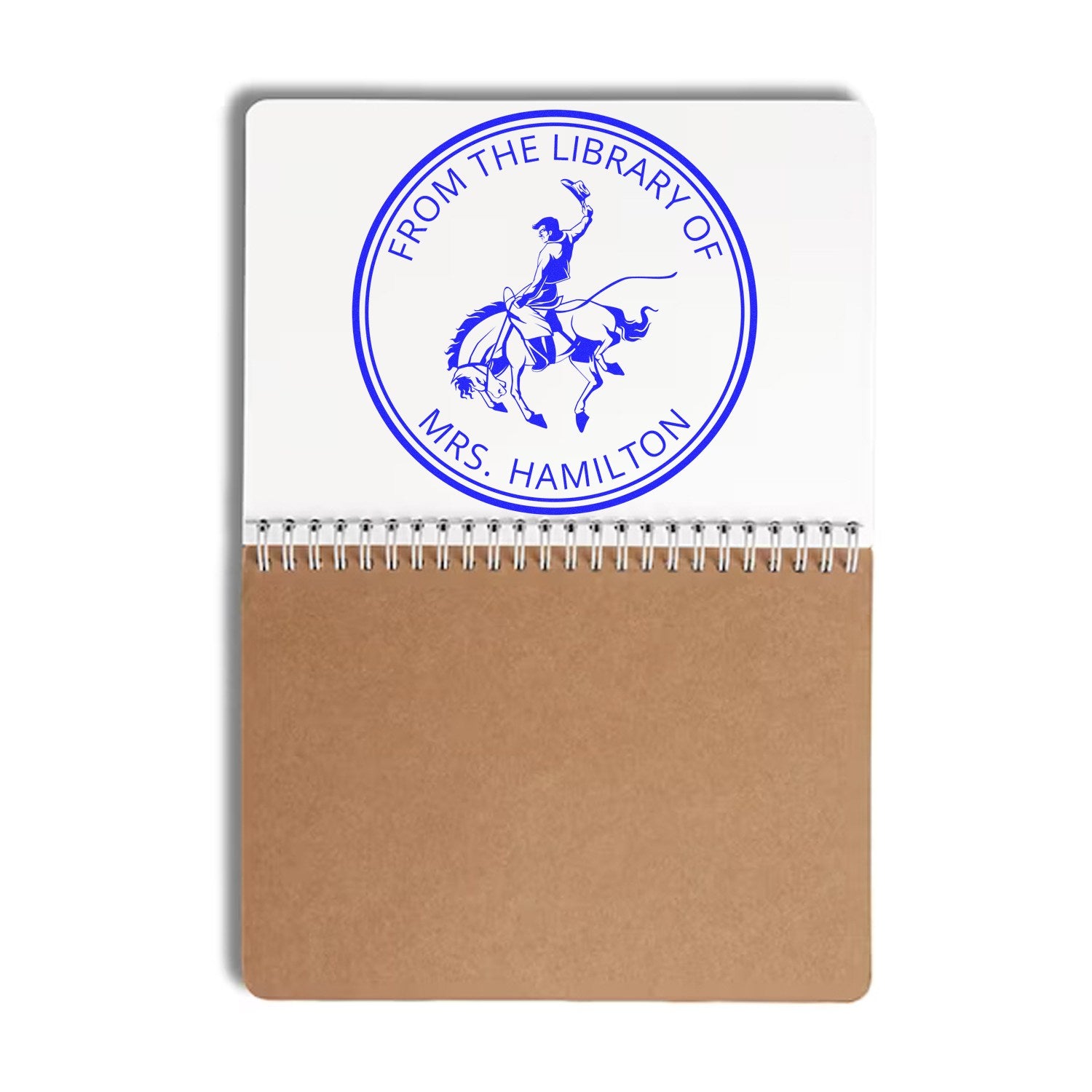 Custom blue library seal stamp on white-and-tan spiral notebook, reading From the Library of Mrs. Hamilton