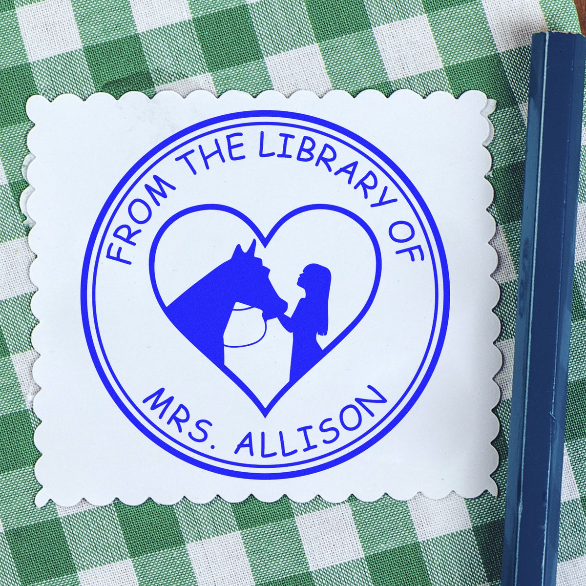Blue custom stamp seal reading From the Library of Mrs. Allison with heart horse-and-girl logo on white scalloped card.