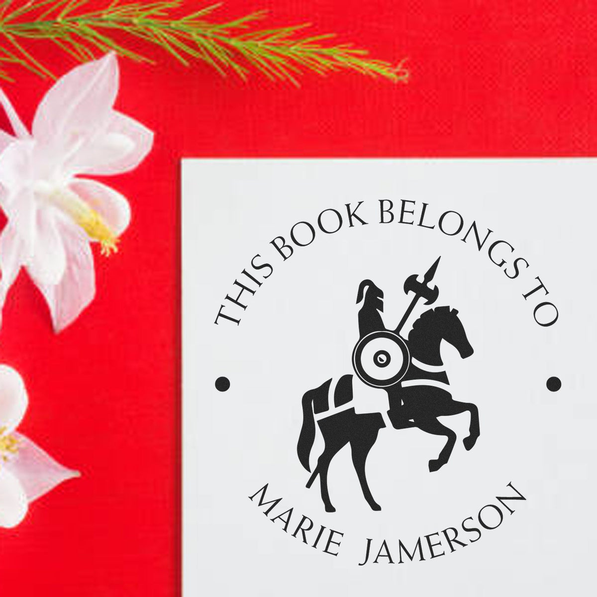 Custom white book seal stamp with black horse-and-rider logo, Marie Jamerson text, on red floral background.
