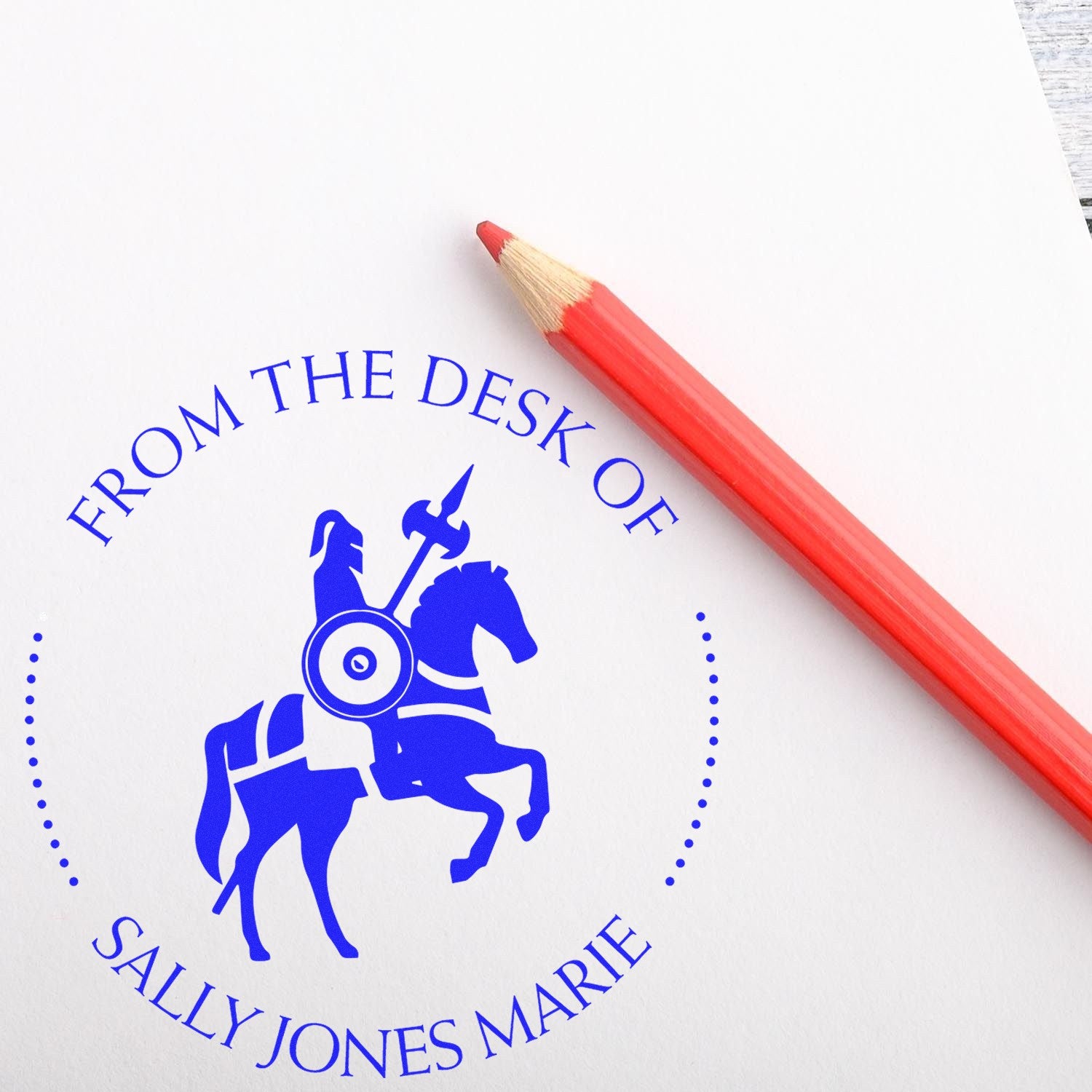 Blue custom stamp seal with horse rider logo and red pencil on white paper.