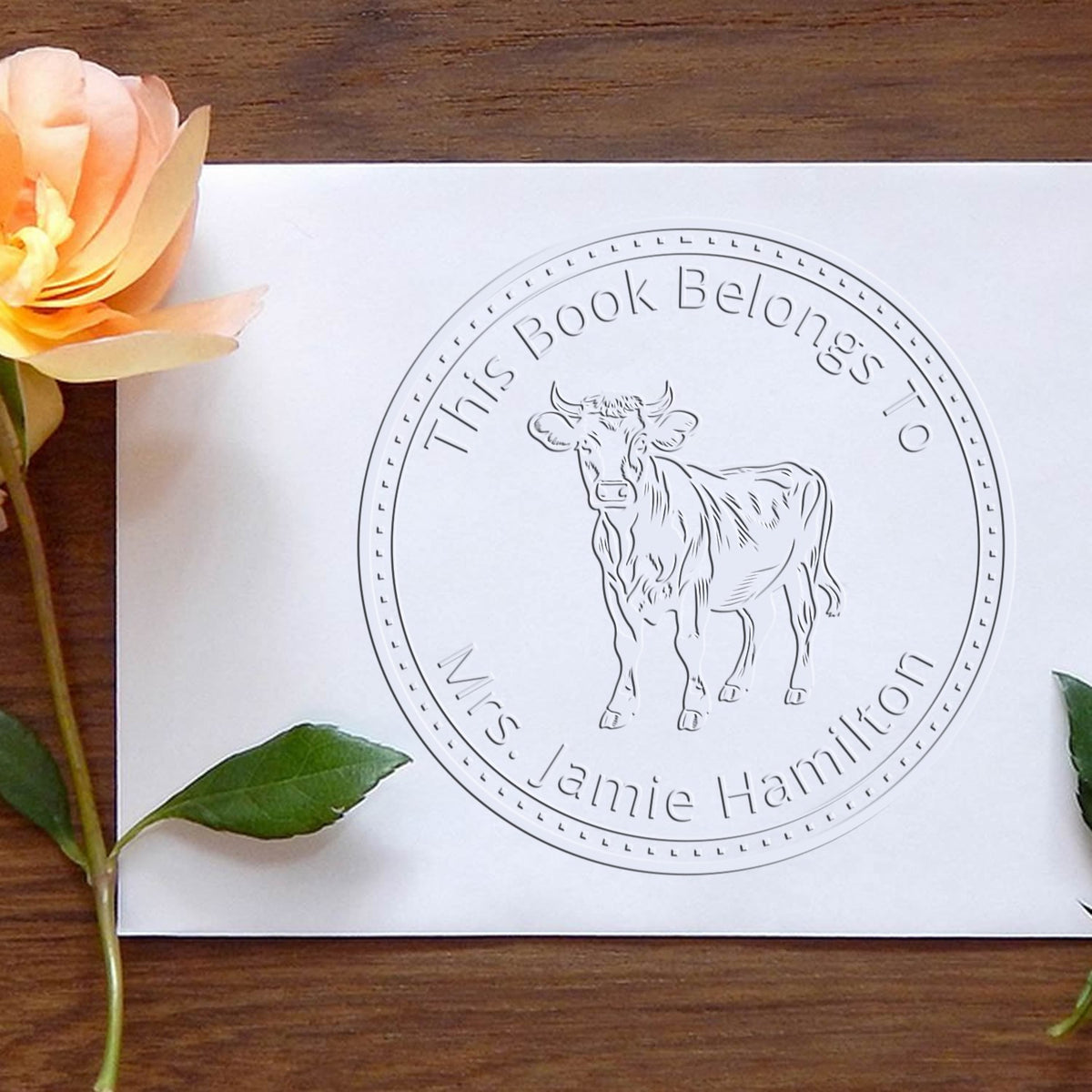 Farm animal stamp featuring a Rosie Cow design from ESS, used to personalize library books with a charming cow image.