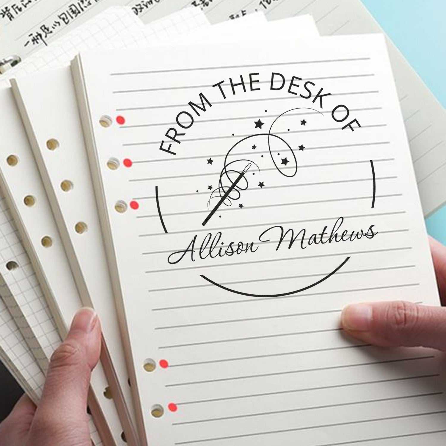 Custom black teacher desk stamp and seal on lined white notebook pages, reading From the Desk of Allison Mathews with stars.