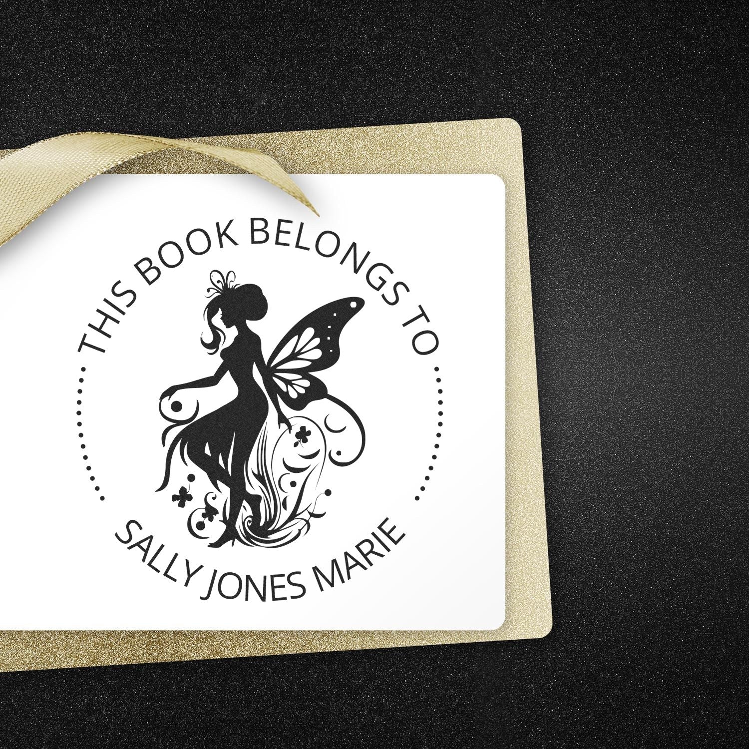 Personalized book belongs stamp and seal with black fairy silhouette, white center, gold glitter border, and satin ribbon.
