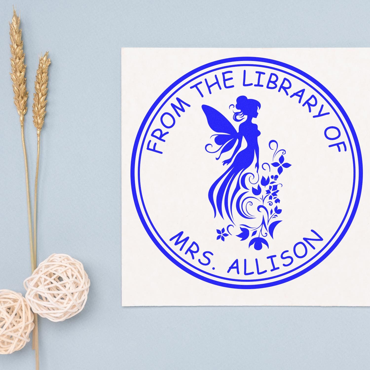 Blue custom library stamp and seal with fairy silhouette and From the Library of Mrs. Allison text on white card